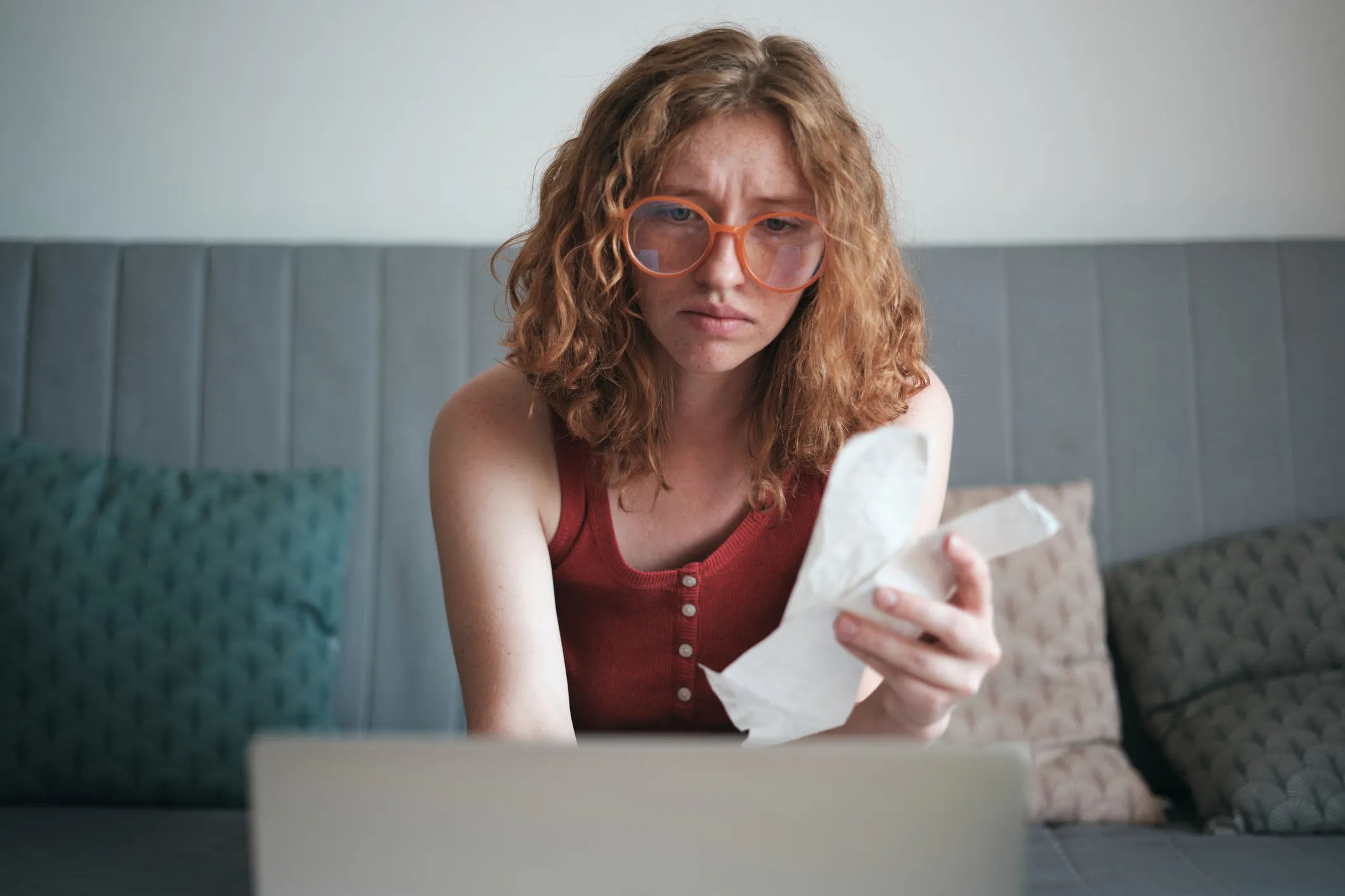Money shy behaviors illustrated by a person hesitantly reviewing financial statements and avoiding investment decisions