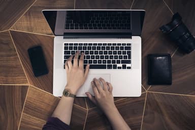 Person typing on a laptop at a desk, illustrating a donor completing an agentic payment through an AI chat