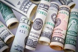 Rolled US dollar bills symbolizing the Revolut US bank charter approval from the OCC