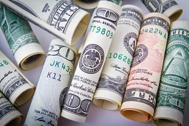 Rolled US dollar bills symbolizing the Revolut US bank charter approval from the OCC