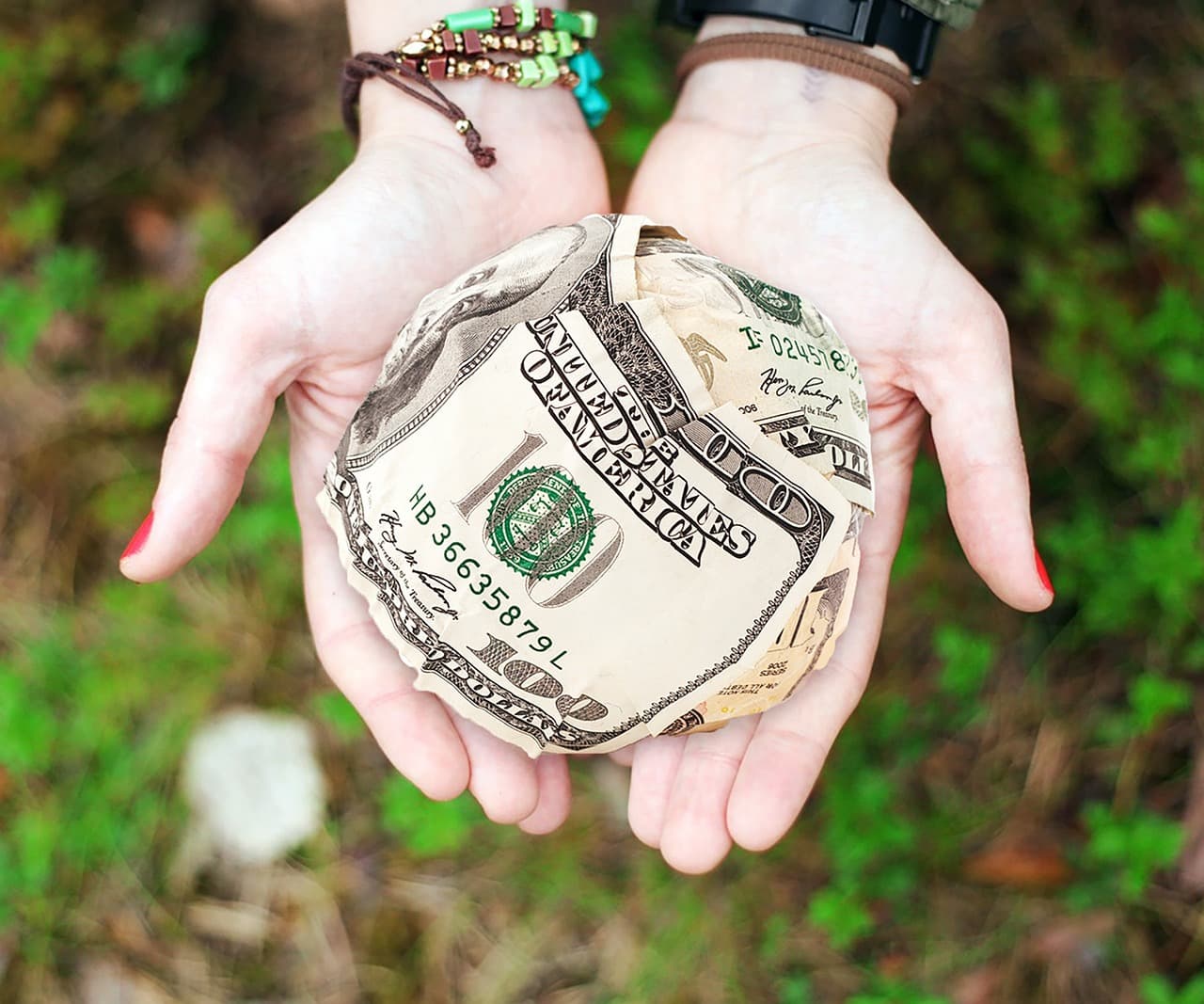 Hands offering banknotes, illustrating Altruist donor-advised funds for charitable giving