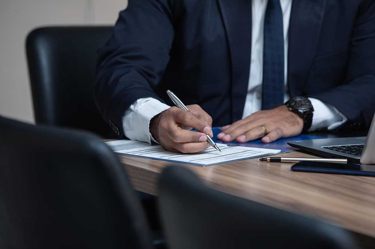 Executive signing documents at an office desk, illustrating Visa Commercial Fraud Solutions for business payments