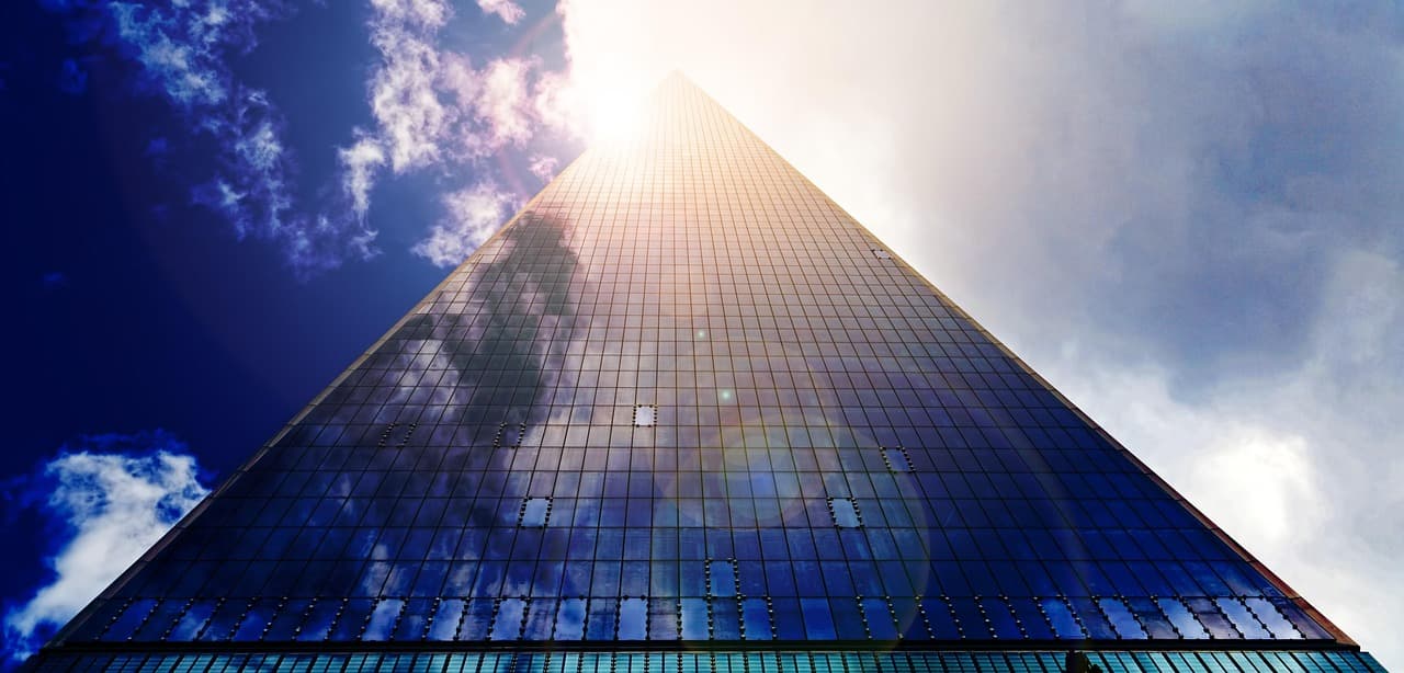 Glass office tower, illustrating Amex cash back deposits into high-yield savings
