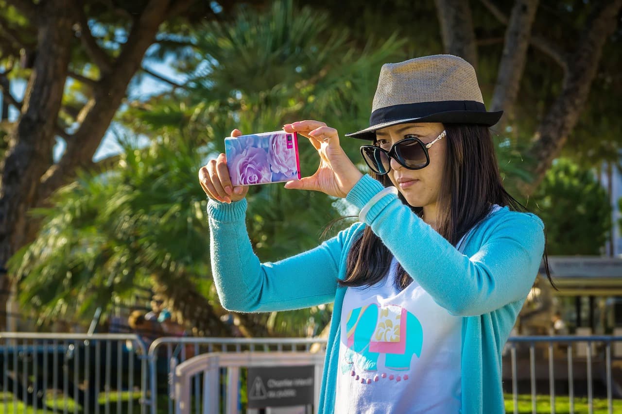 Woman taking a selfie on a smartphone, illustrating Bron FaceScan wallet recovery