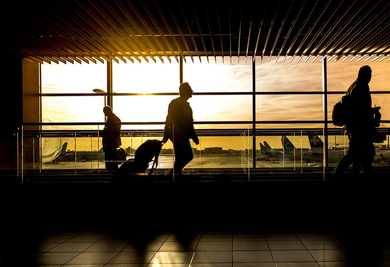 Travellers walking through an airport terminal, illustrating the ConnexPay MIDOCO integration for travel payments