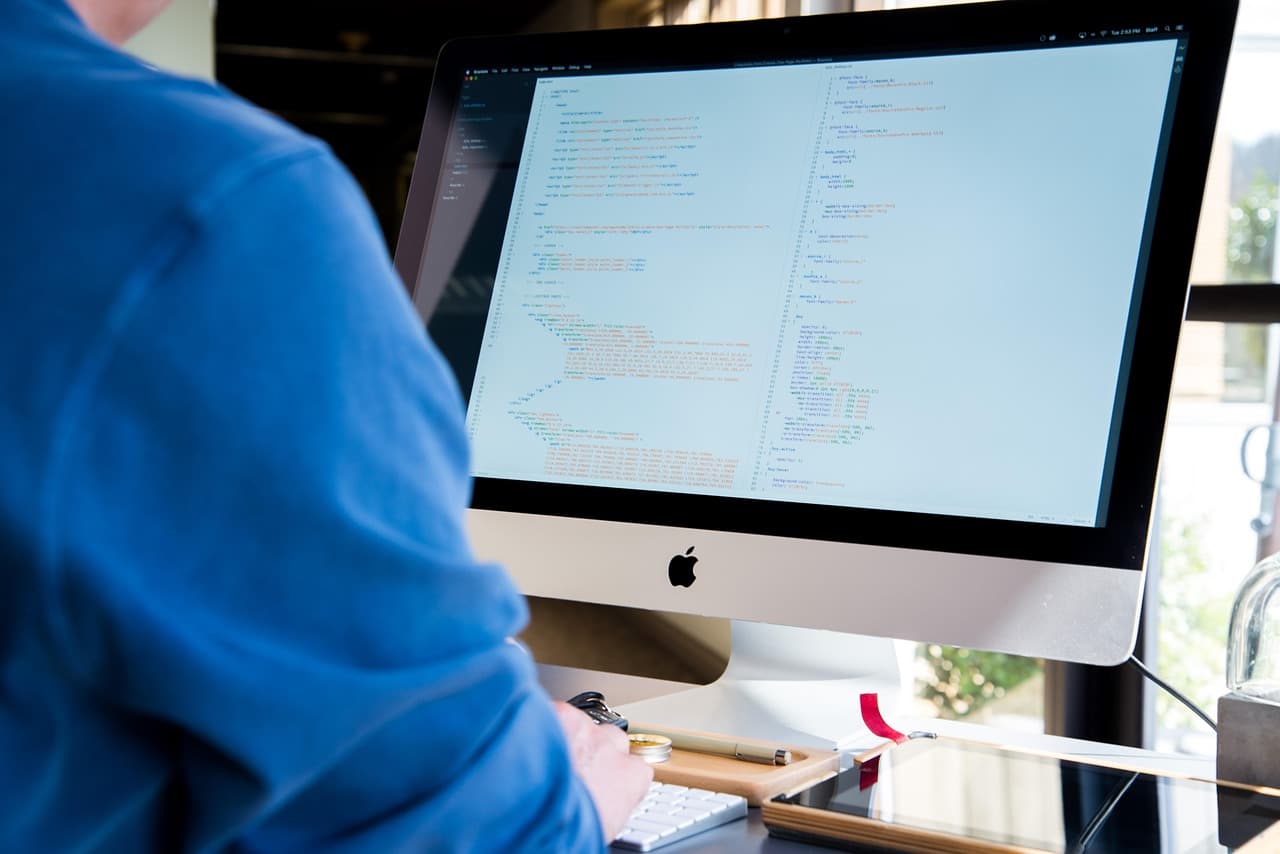 Developer writing code on a computer, illustrating Payroc for Developers payment integrations