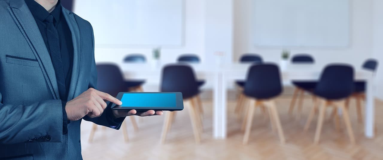Businessman with a tablet in an office, illustrating Payroc research on payment integrations