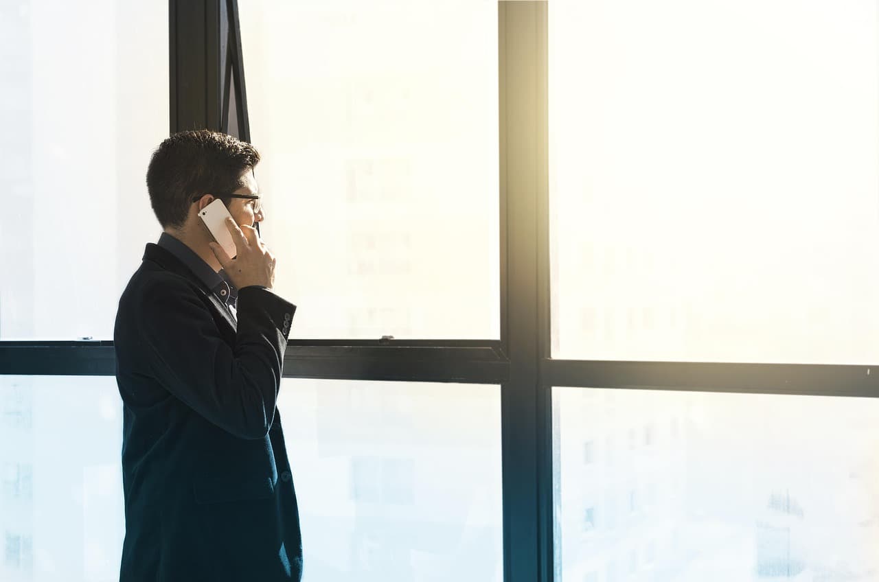 Businessman on a phone call by an office window, illustrating the PaysafeWallet European expansion