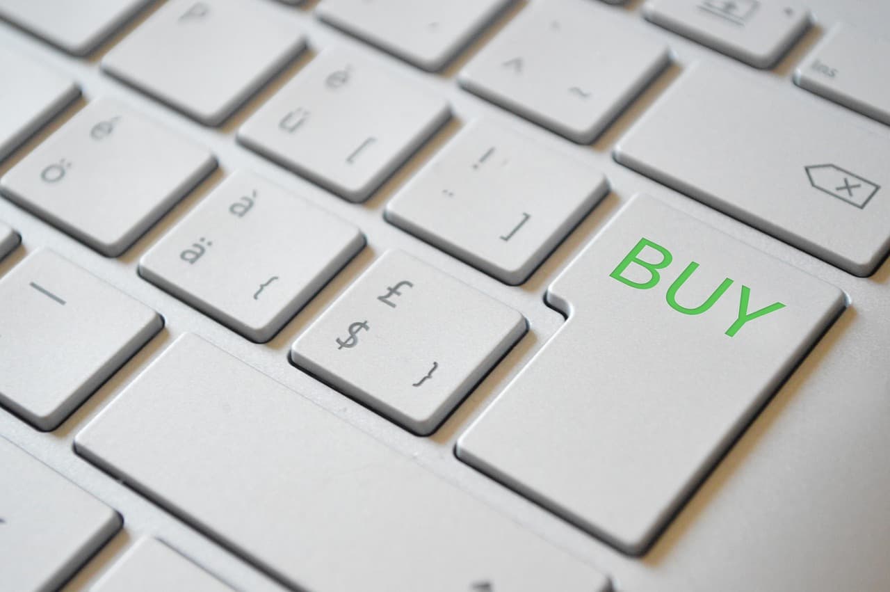 A computer keyboard with a green BUY key